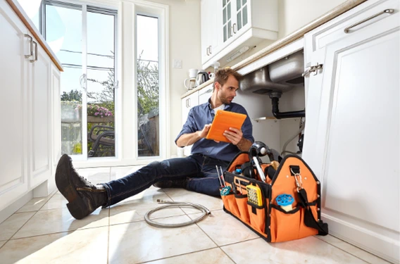 plumber is fixing kitchen water leak